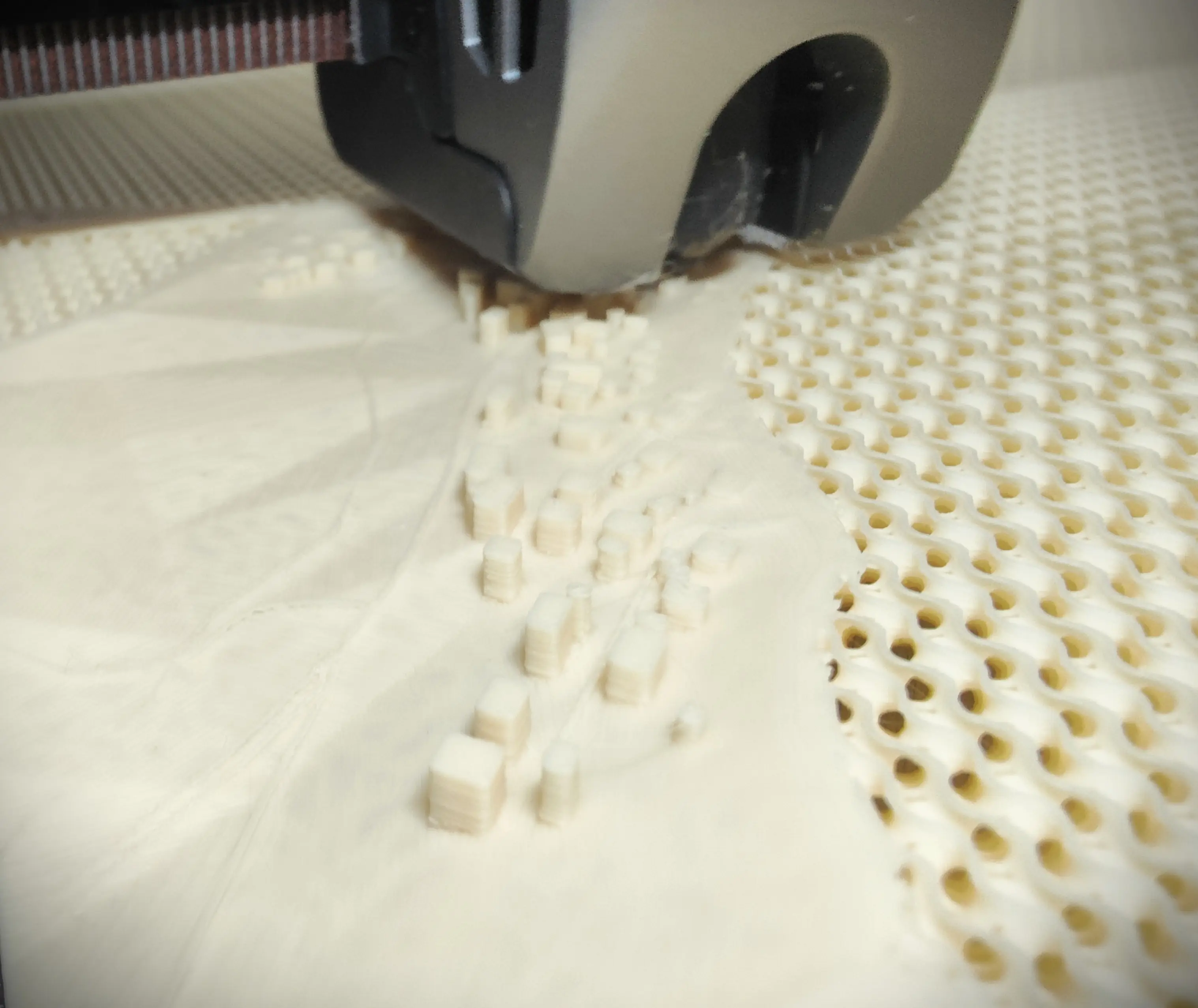 3D-gedruckte Stadtkarte von Schechingen aus cremeweißem PLA, während der 3D-Drucker die Schichten aufträgt. Das Modell ist zu etwa 50 % fertig und zeigt den fortschreitenden Druckprozess.