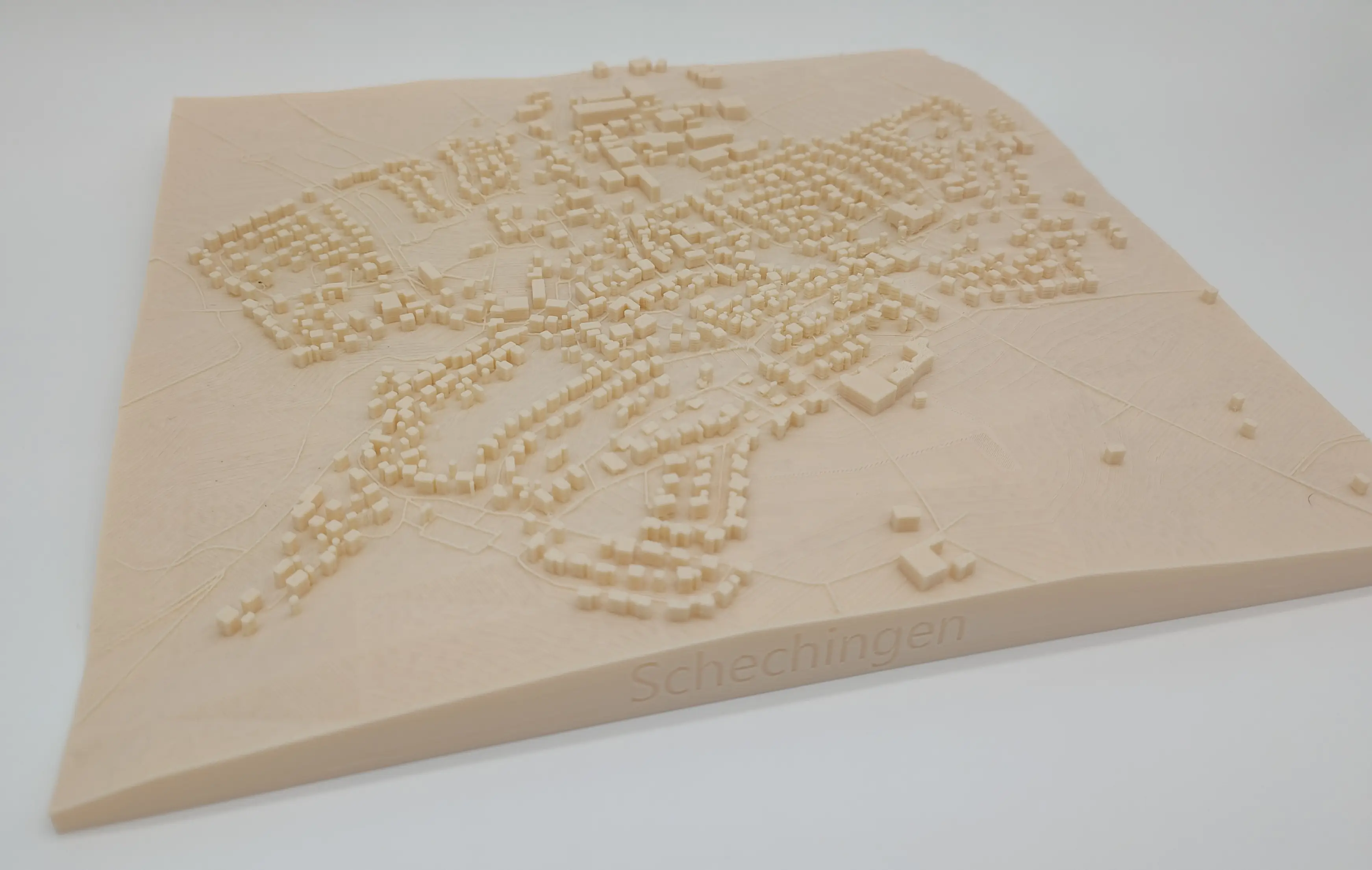 3D-gedruckte Stadtkarte von Schechingen aus cremeweißem PLA, auf einem weißen Hintergrund. Die Karte zeigt die detaillierte Topografie der Stadt im Miniaturformat.
