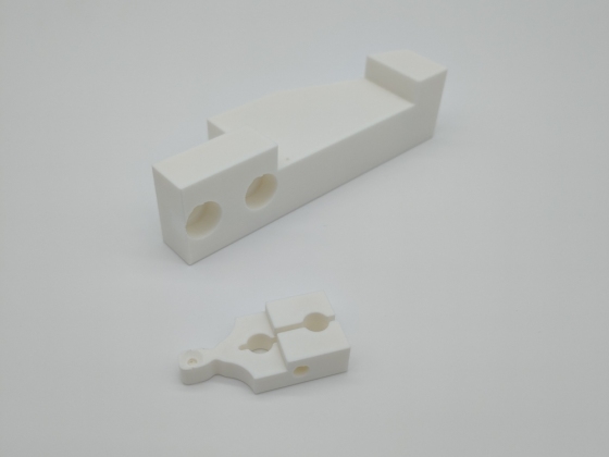 Zwei weiße 3D-gedruckte Prototypenteile aus PLA auf neutralem, weißem Hintergrund. Präzisionsdruck für technische Anwendungen im Prototypenbau.